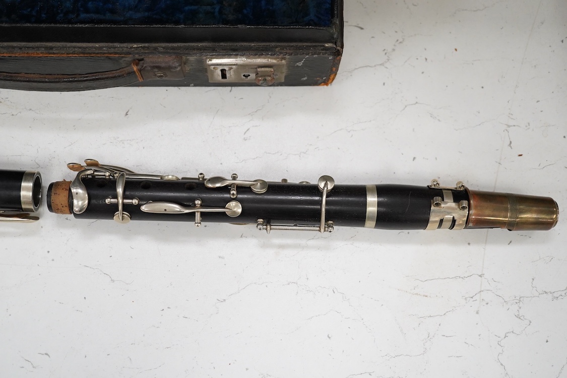 An early 20th century wooden Boosey and Hawkes clarinet in a fitted leather case